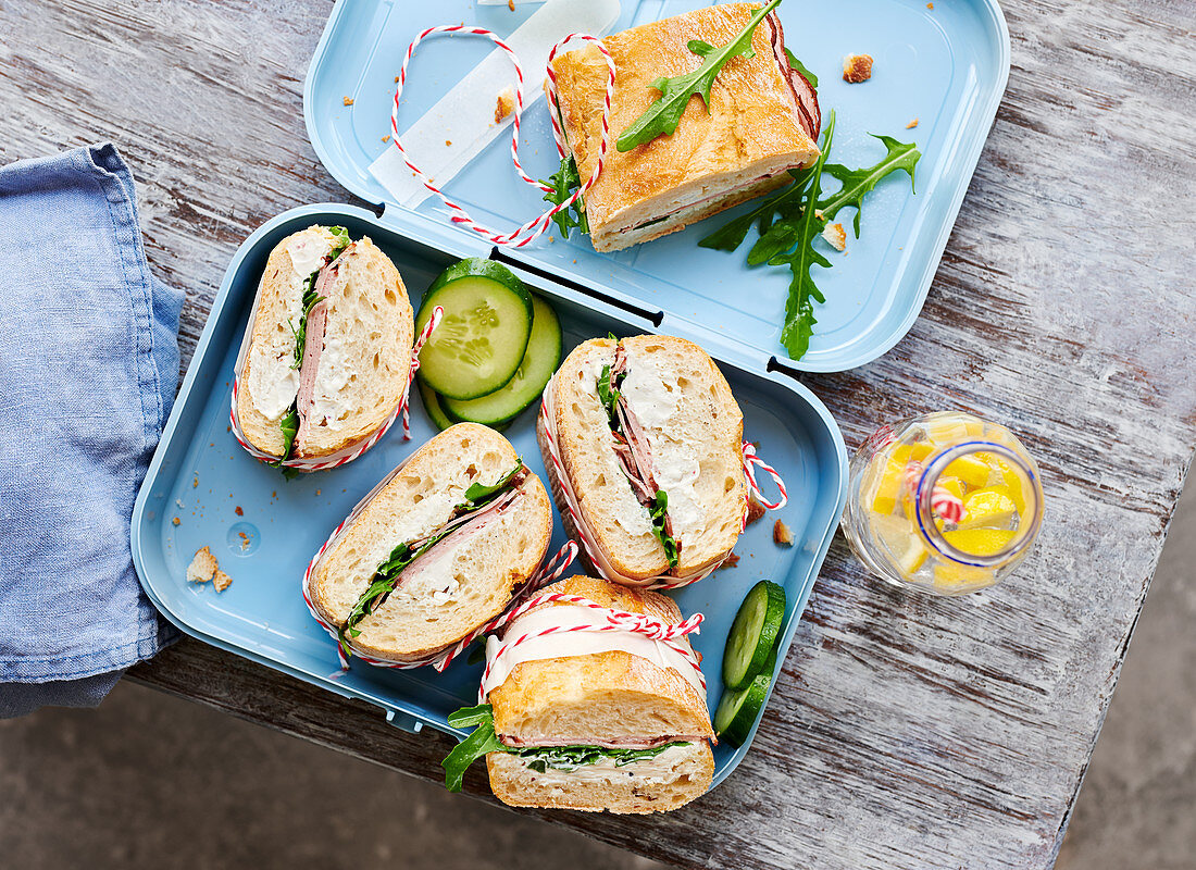 Baguette-Sandwiches mit Leberkäse, Meerrettich, Frischkäse und Rucola in Lunchbox