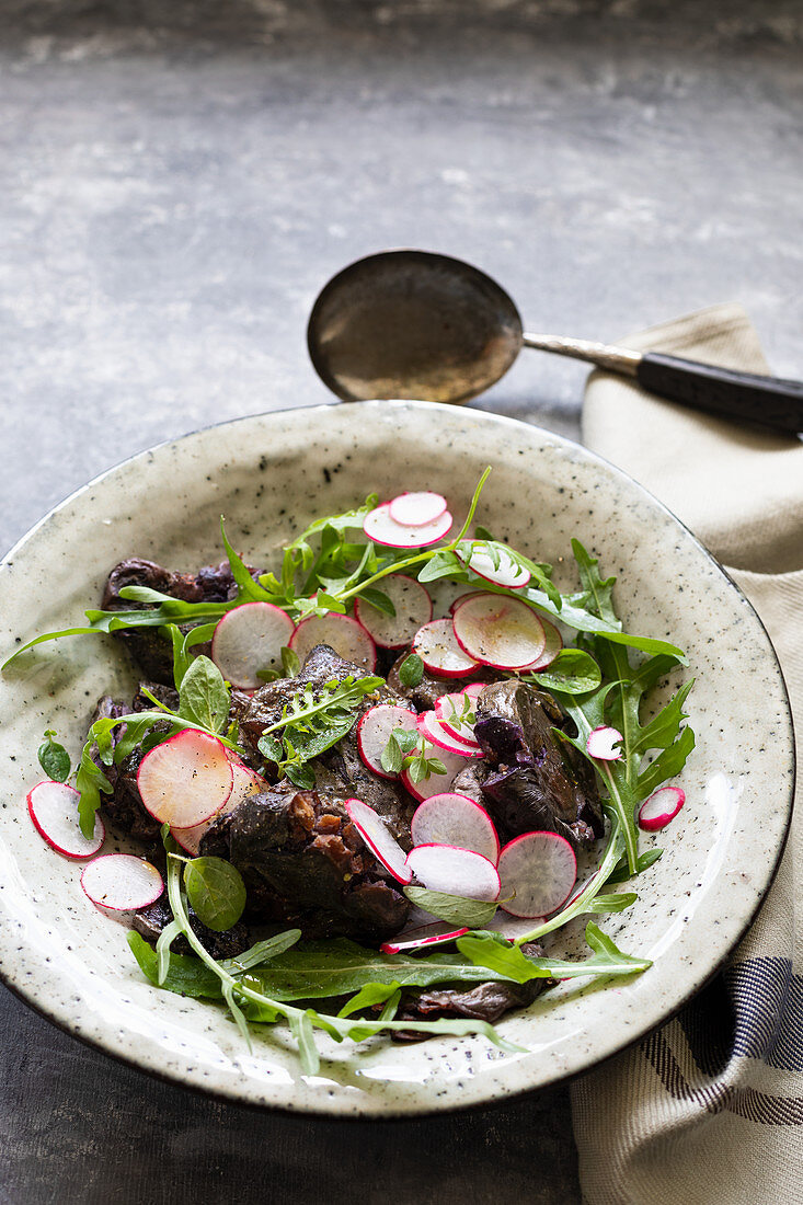 Salat mit gebratenen zerdrückten roten Kartoffeln, Radieschen und Rucola