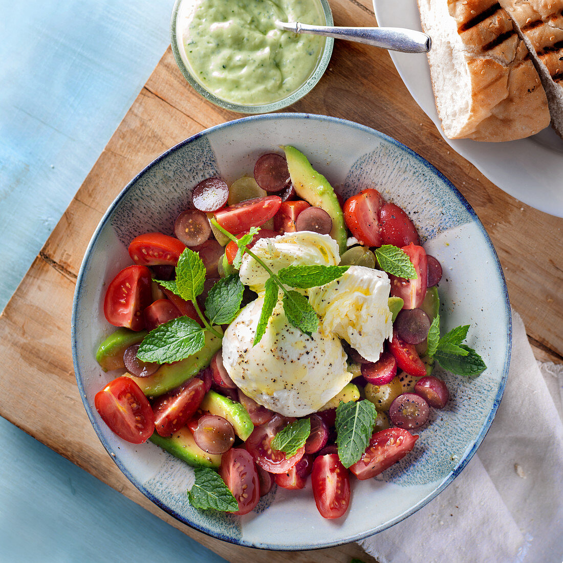 Avocado and tomato salad with grapes, mozzarella, mint and mint yoghurt dressing