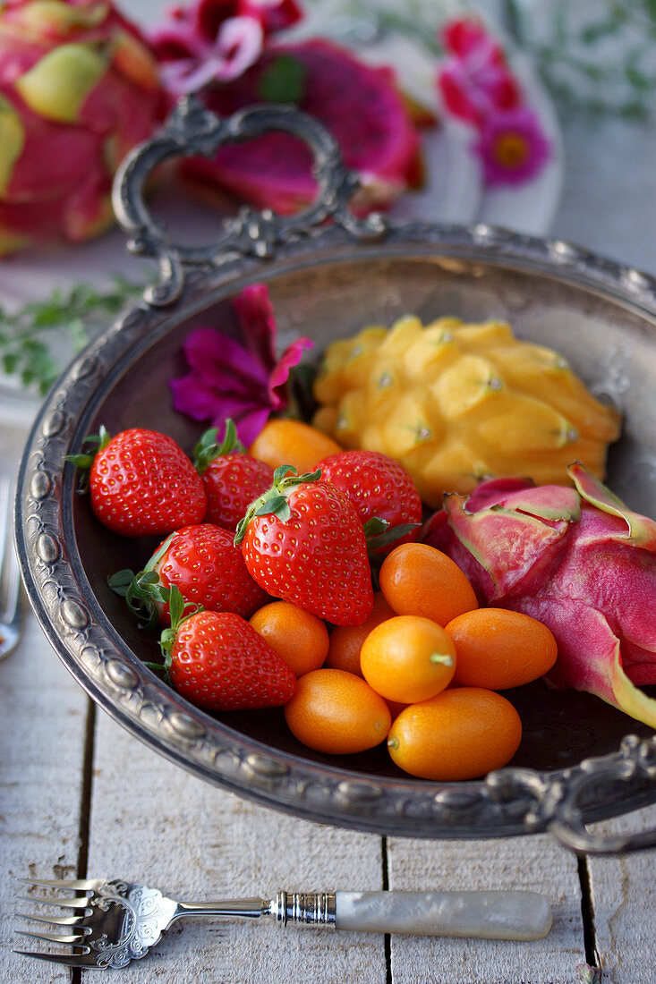 Erdbeeren, Kumquats und Pitahayas in eleganter Obstschale