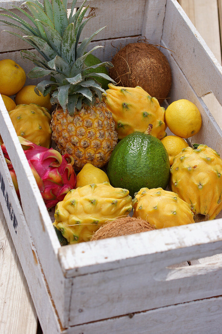 Various exotic fruits in a white wooden box