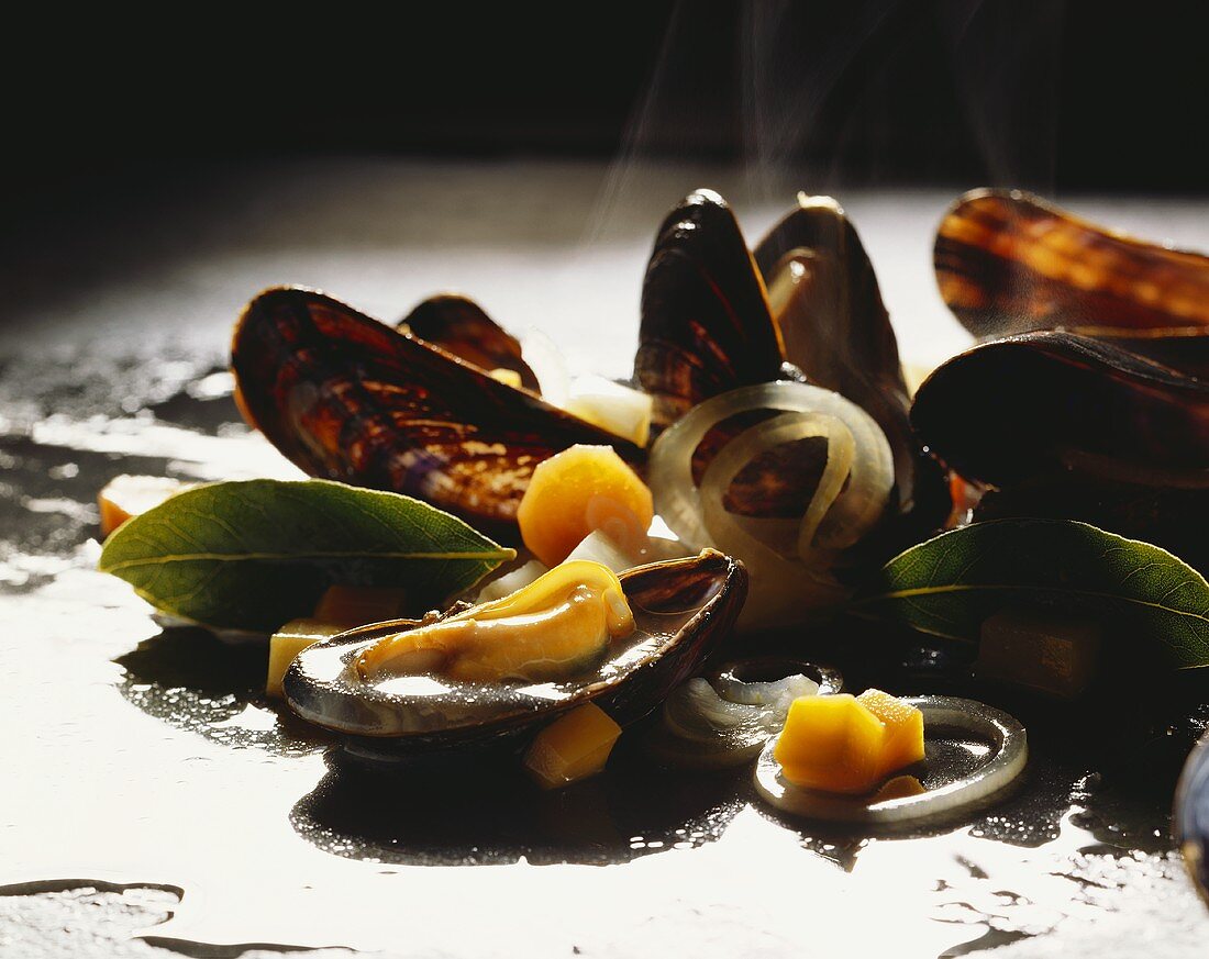 Steam rising from cooked mussels with white wine stock