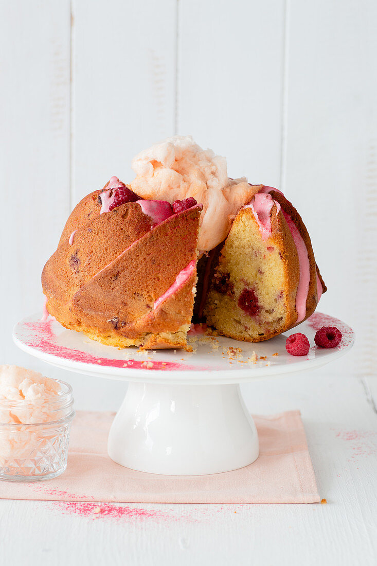 Himbeergugelhupf mit Zuckerwatte, angeschnitten auf Kuchenständer