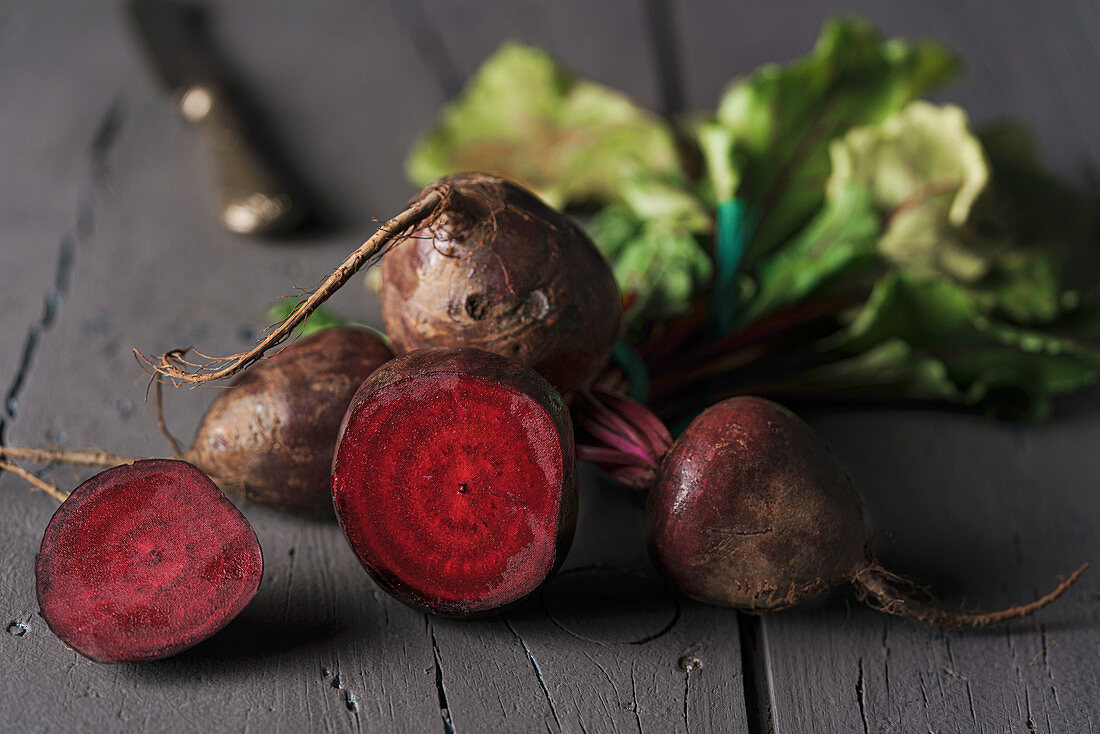 Red sugar beetroots on stem with green leaves