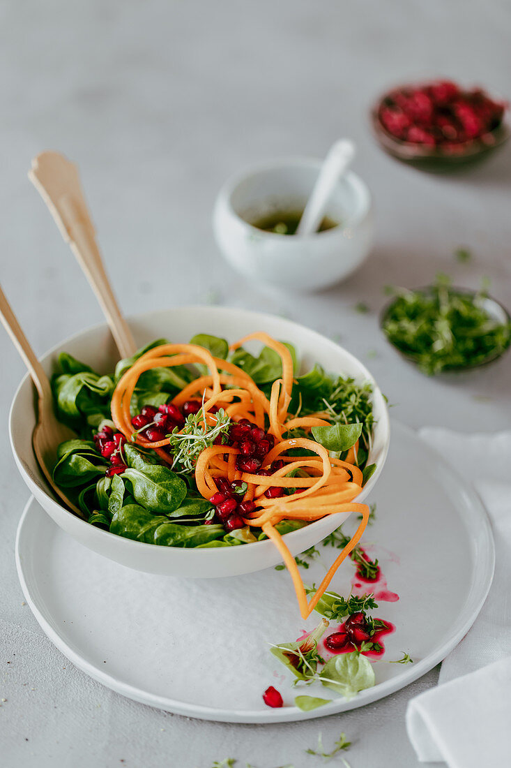 Lambs lettuce with carrot noodles and pomegranate seeds
