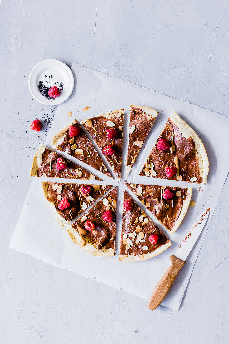 Chocolate pizza with raspberries and almond flakes