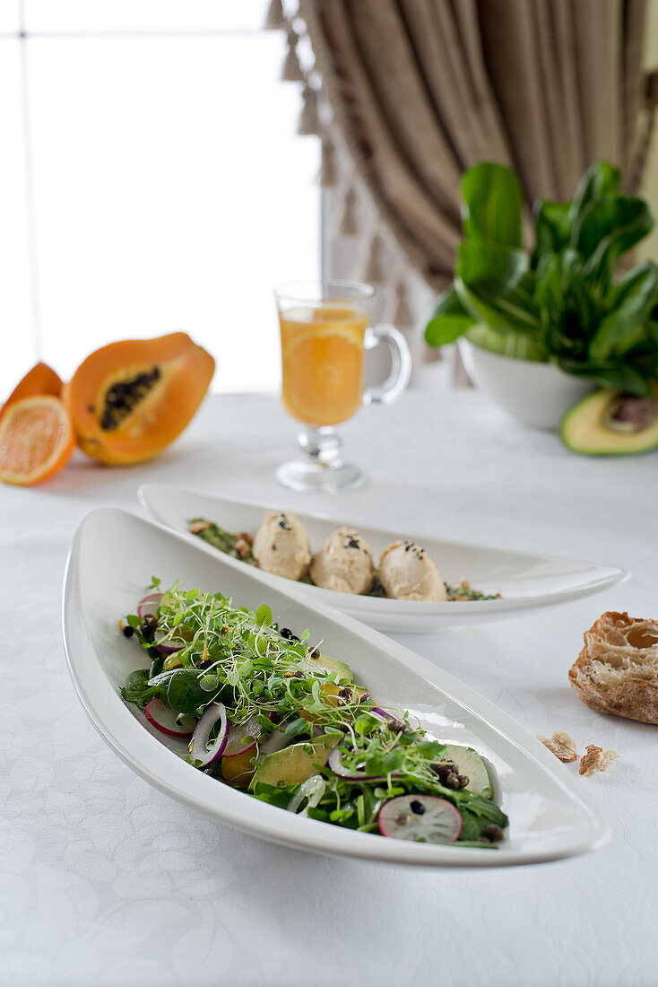 Salad with avocado, papaya and radishes and fish cakes