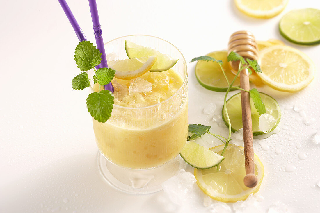 Mango-Reis-Shake mit Limetten und Honig im Glas mit Trinkhalm