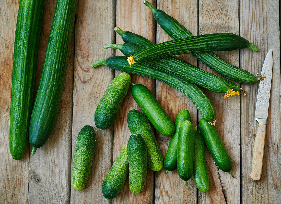 Fresh cucumbers on a wooden background with knife