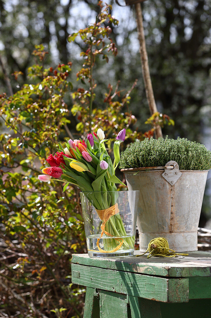 Colourful bouquet of tulips in glass vase on garden