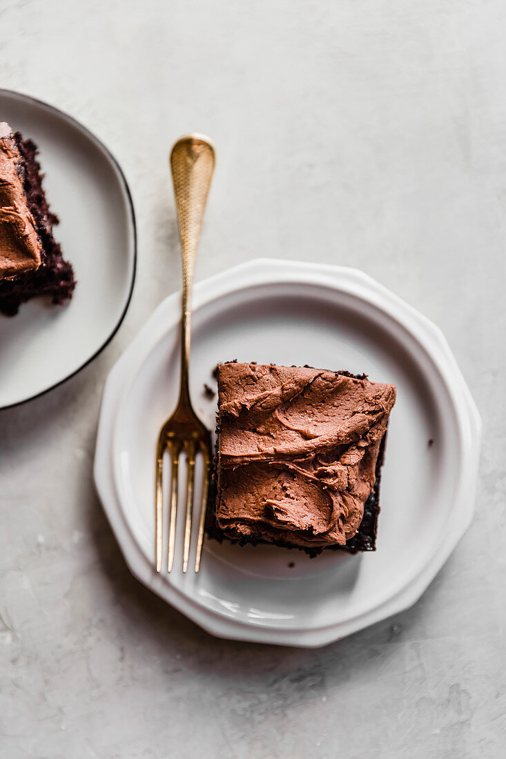 Ein Stück Schokoladenkuchen vom Blech mit Schoko-Buttercremefrosting