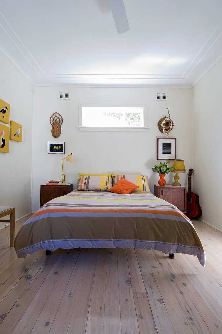 Double bed with striped bedspread and bedside cabinets in bedroom