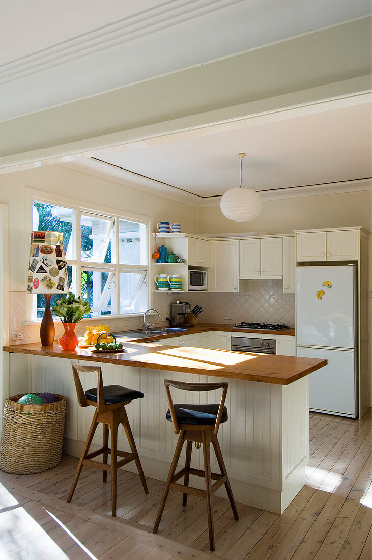 Breakfast bar in open-plan cream kitchen