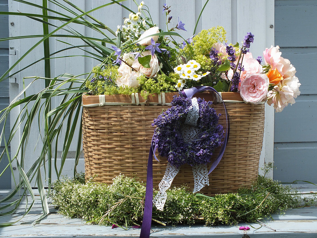 Korb mit Lavendelkranz und Sommerstrauß aus Rosen, Gräsern und Lavendelblüten