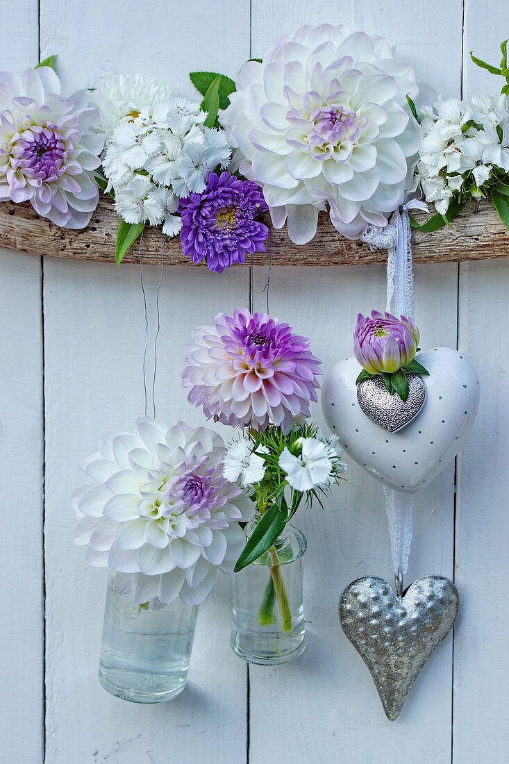 Heart decorations and small suspended bottles holding dahlias, asters and sweet Williams