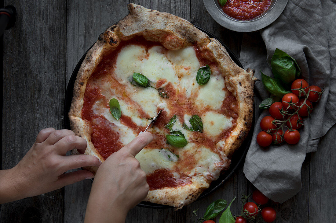 Pizza Margherita anschneiden