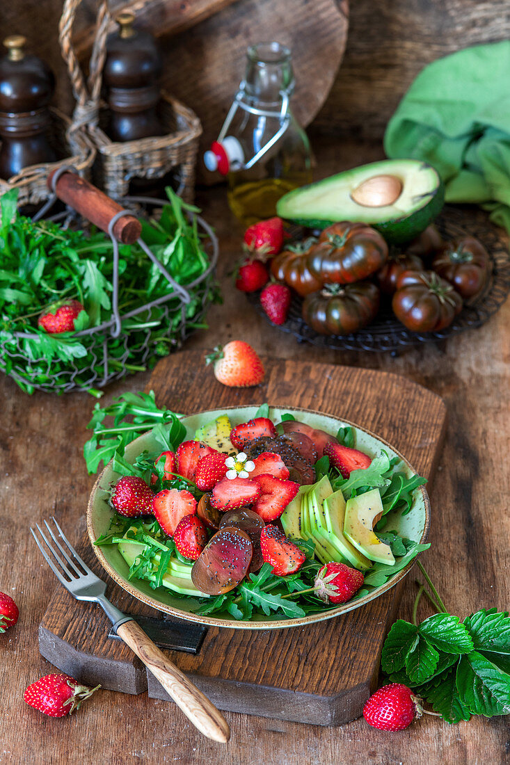 Erdbeersalat mit Rucola, schwarzen Tomaten und Avocado