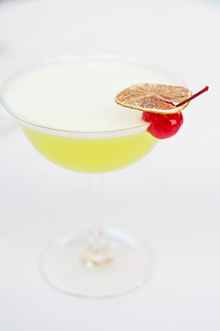 Cocktail garniert mit Cocktailkirsche und Limettenscheibe