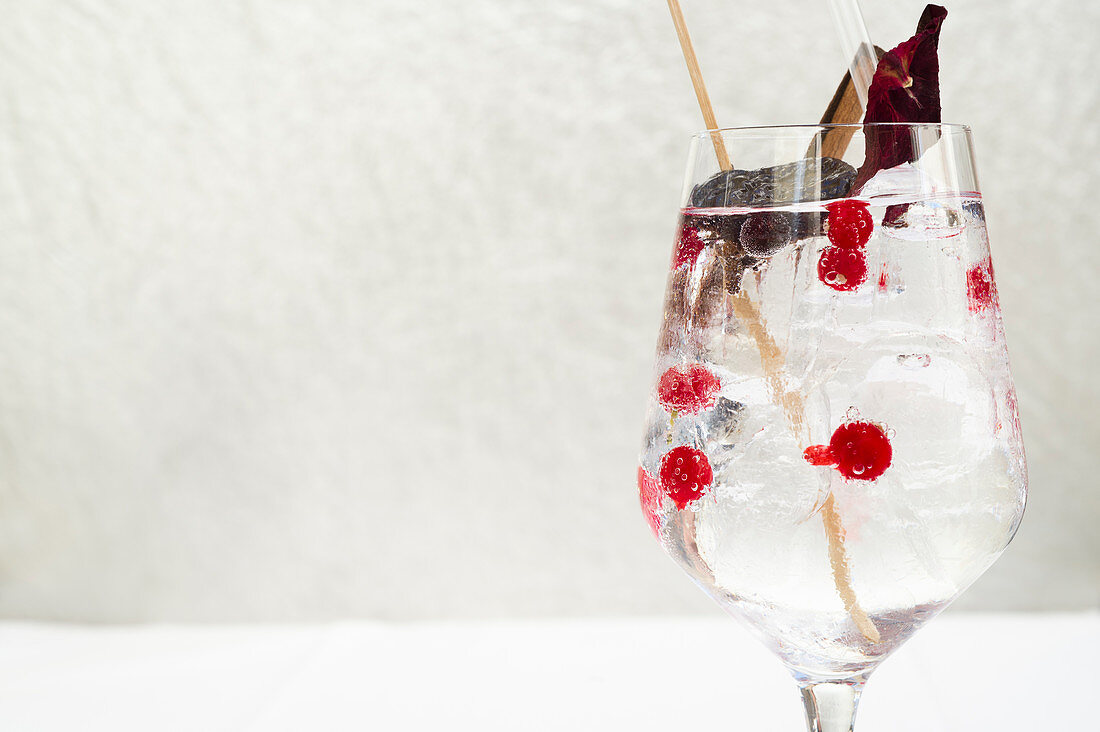 A drink with ice cubes and berries