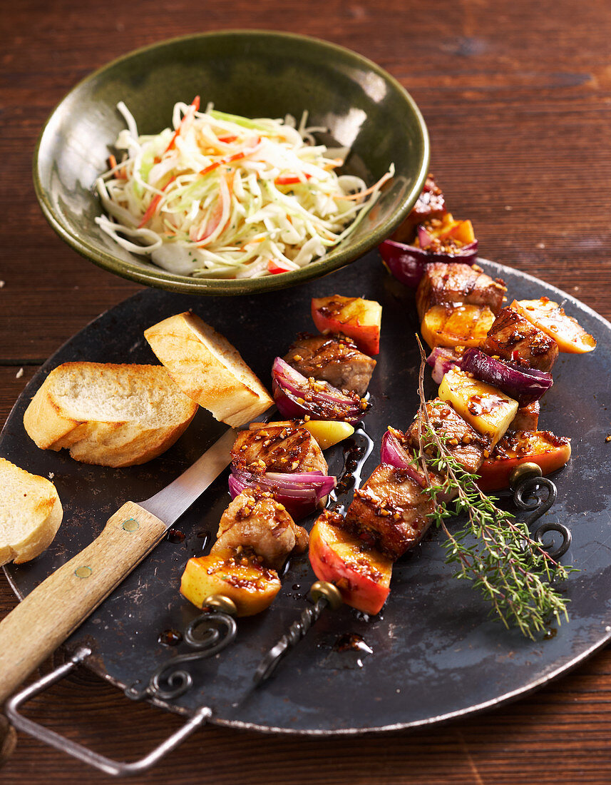 Grilled apple and pork skewers with coleslaw and grilled white bread