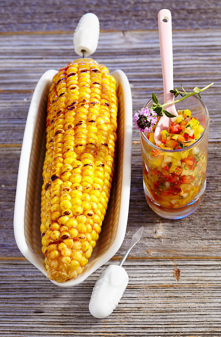 Marinated, grilled corn cobs with a pepper salsa