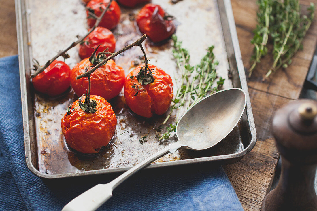 Roasted vine tomatoes with thyme on a baking tray