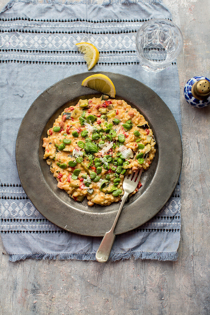 Barley risotto with bacon, basil, broad beans, peppers and zucchini