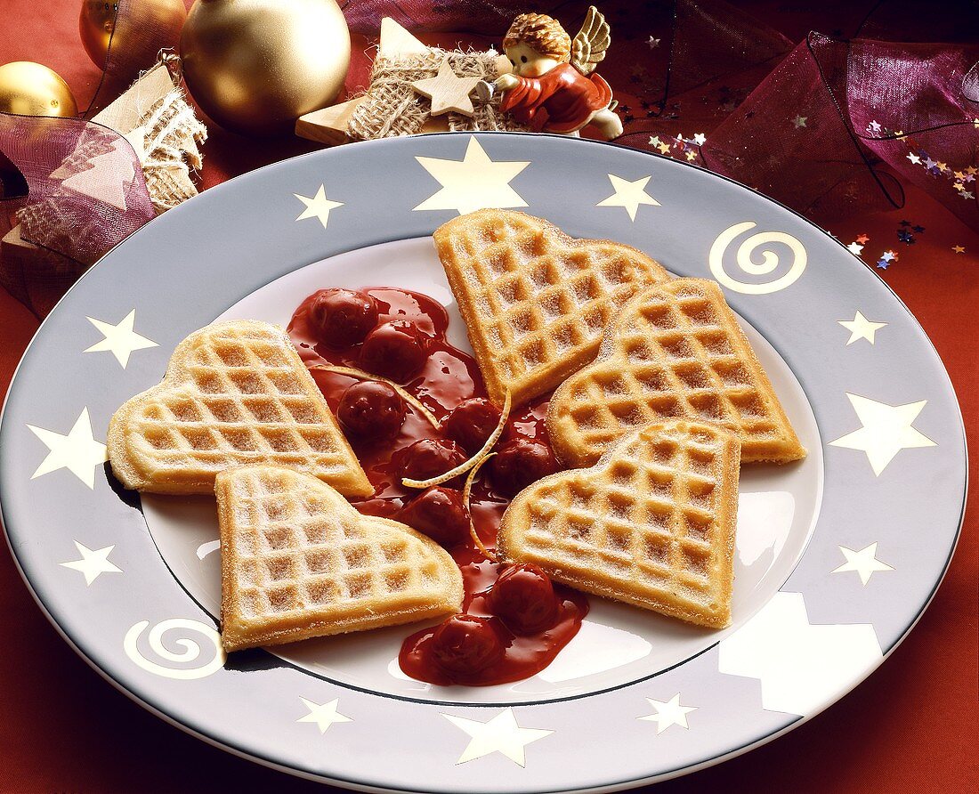 Wafer hearts with icing sugar on cherry compote on a plate