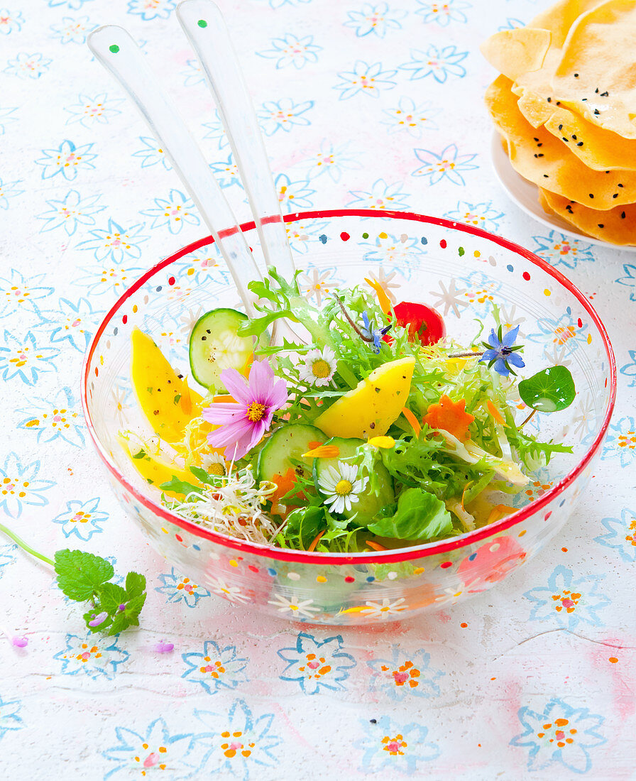 A salad with flowers in a glass bowl