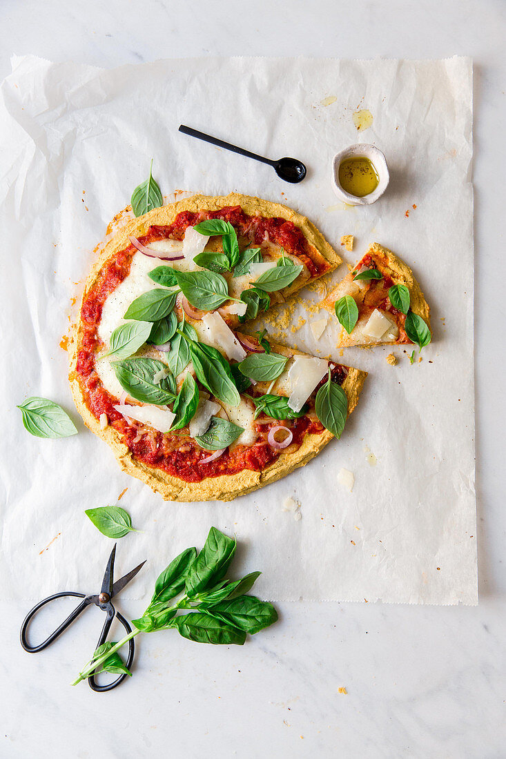 Chickpea pizza with tomatoes, cheese and basil