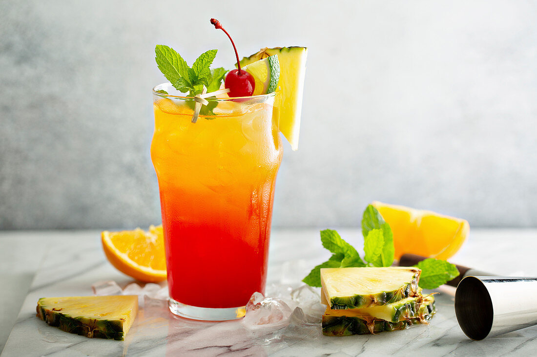 Tequila Sunrise mit Ananas und Orange als Deko