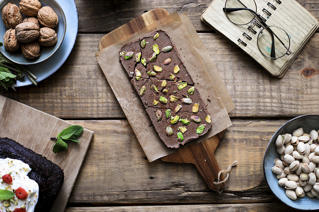 Tasty chocolate dessert garnished with pistachios on baking paper