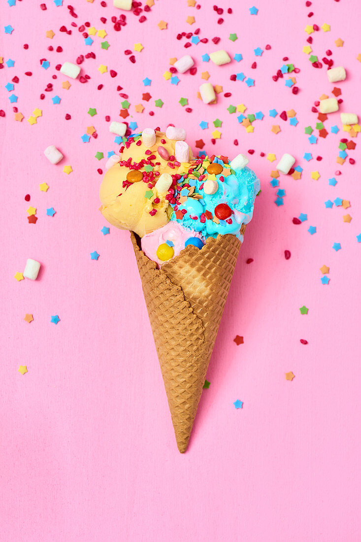 Ice cream cone with colorful ice cream, mini marshmallows, and sugar stars