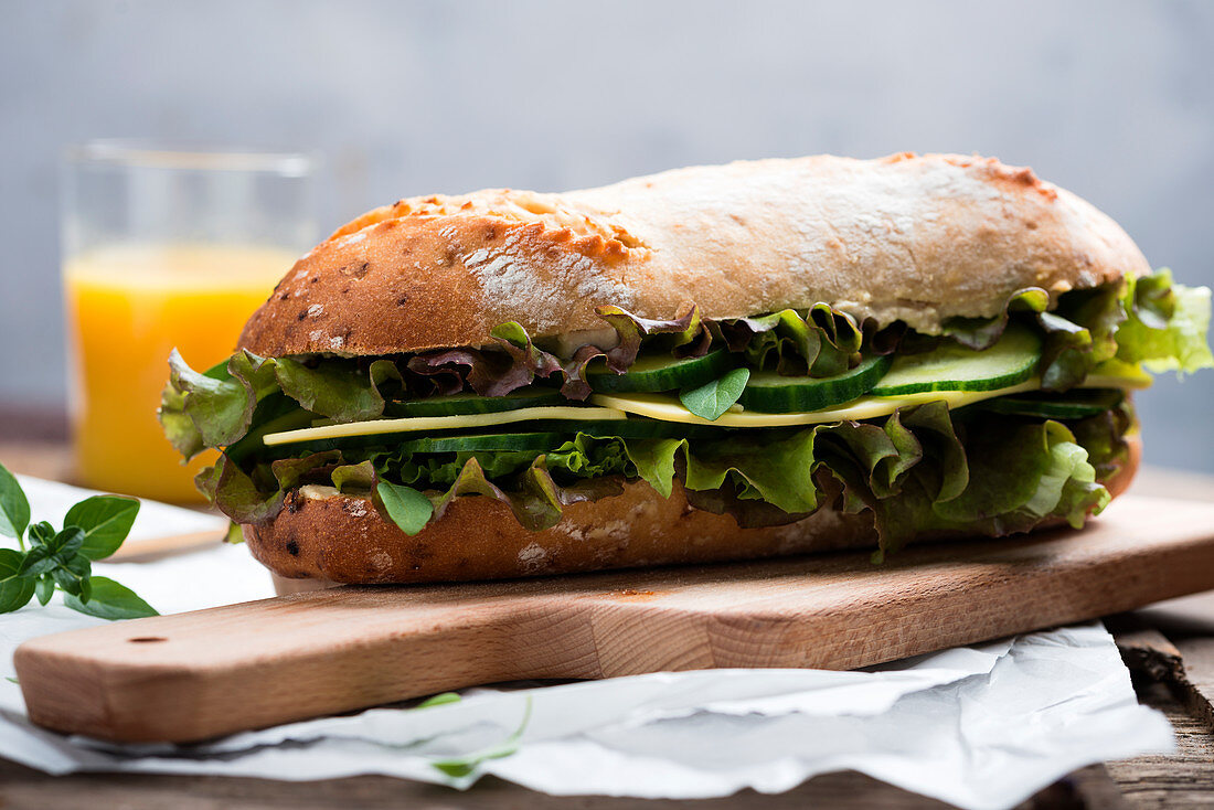 Onion baguette topped with substitute cheese, lettuce and cucumber