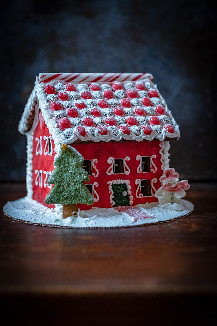 A beautifully decorated red gingerbread house