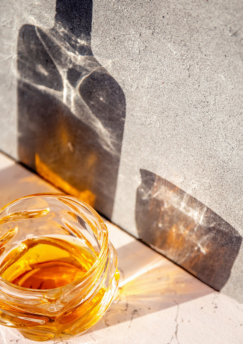 Whiskey im Glas, Schattenwurf von Flasche und Glas