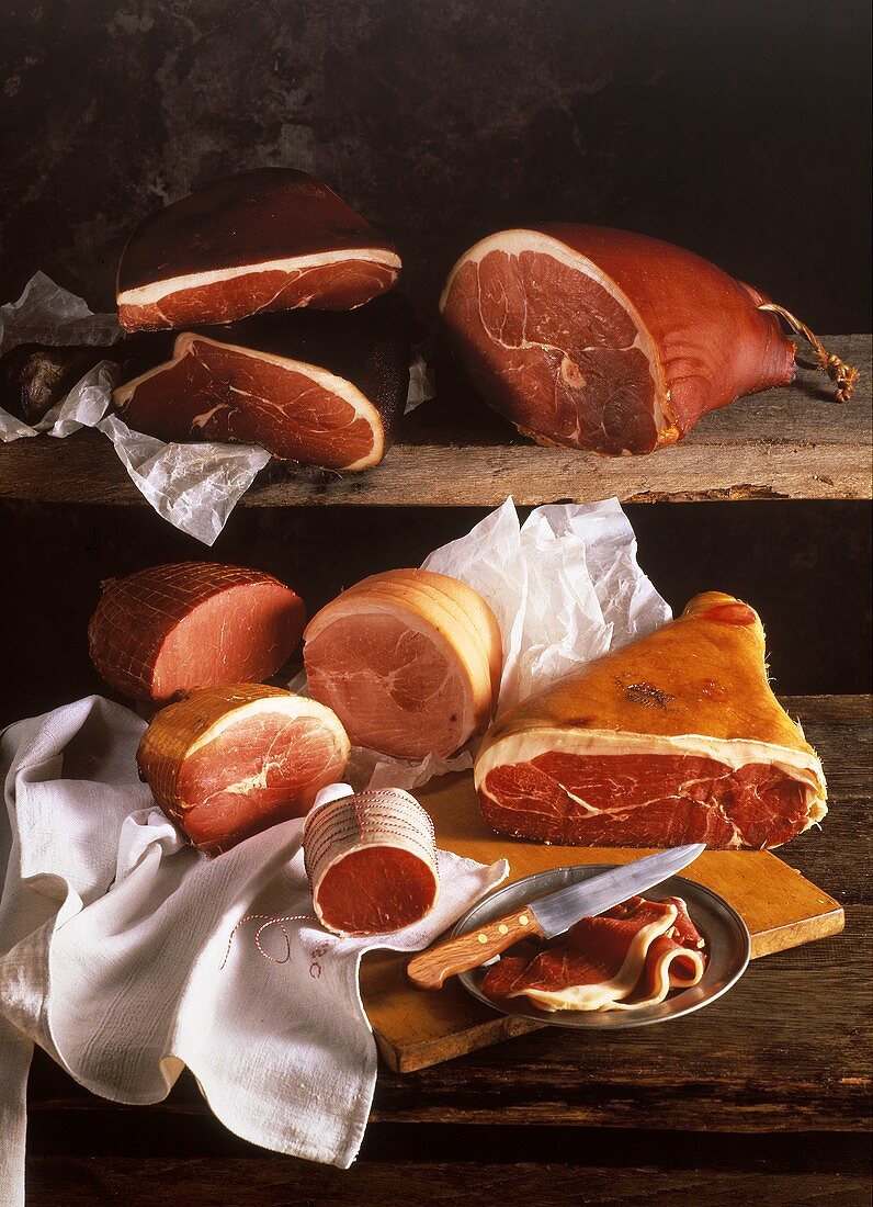 Several Assorted Hams on Wood