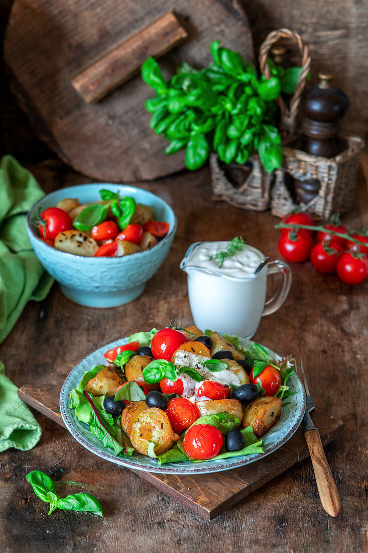 Warmer Kartoffelsalat mit Tomaten, Oliven und Joghurtsauce