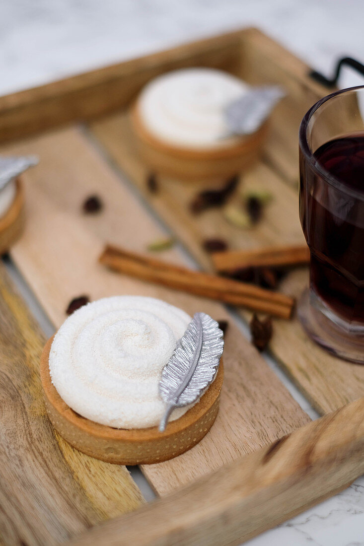 Mulled wine tarts topped with cream and decorated with a silver feather