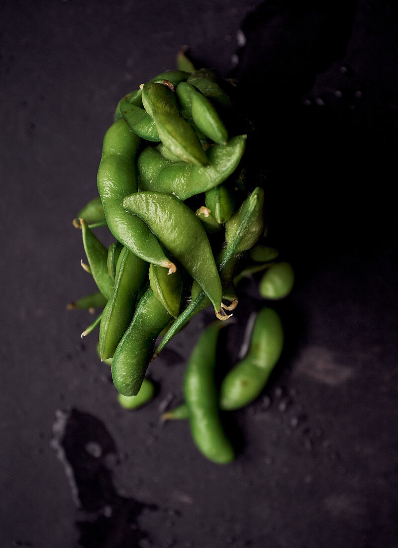 Edamame on a black stone surface