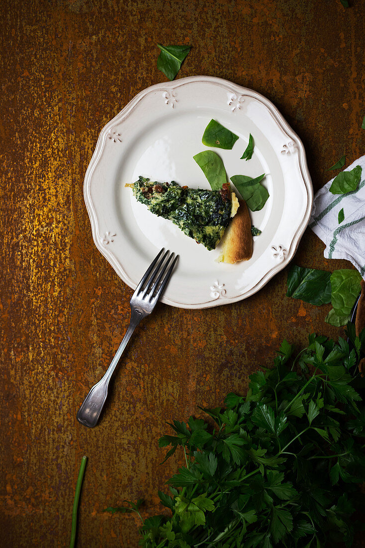 Ein Stück vegetarische Quiche mit Petersilie