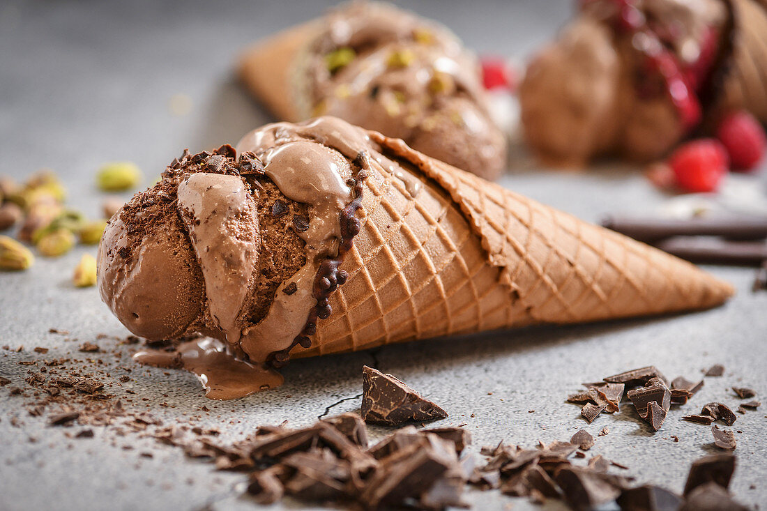 Chocolate ice cream in a waffle cone with different toppings