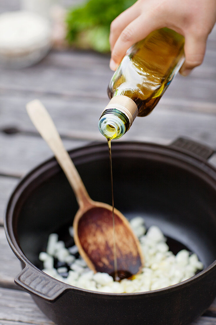 Olivenöl in einen Topf gießen