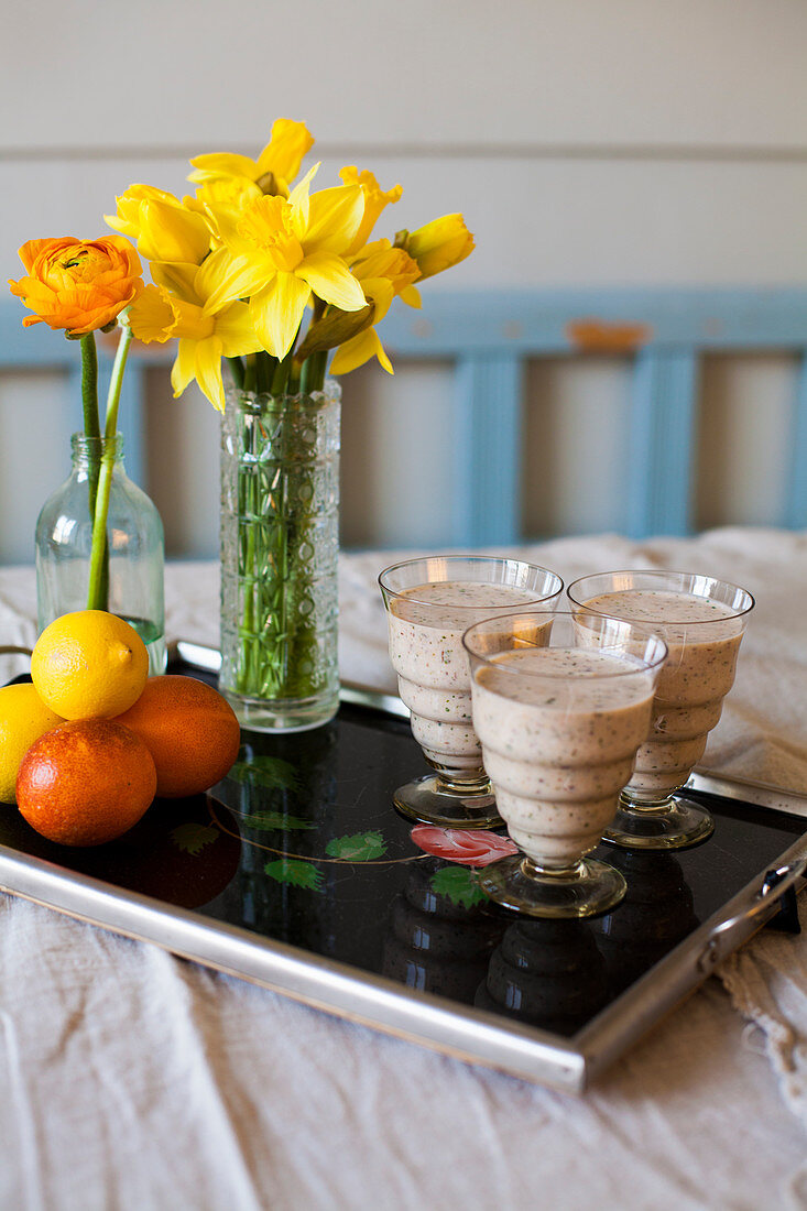 Smoothies mit Blumen und Früchten auf einem Tablett