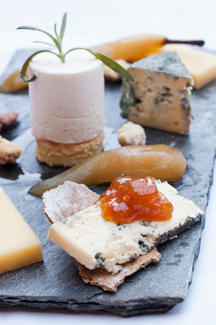 A cheese plate with mustard jam, poached pear and crackers