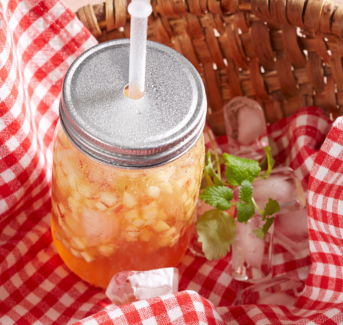 Apple and vanilla iced tea in a basket for a picnic