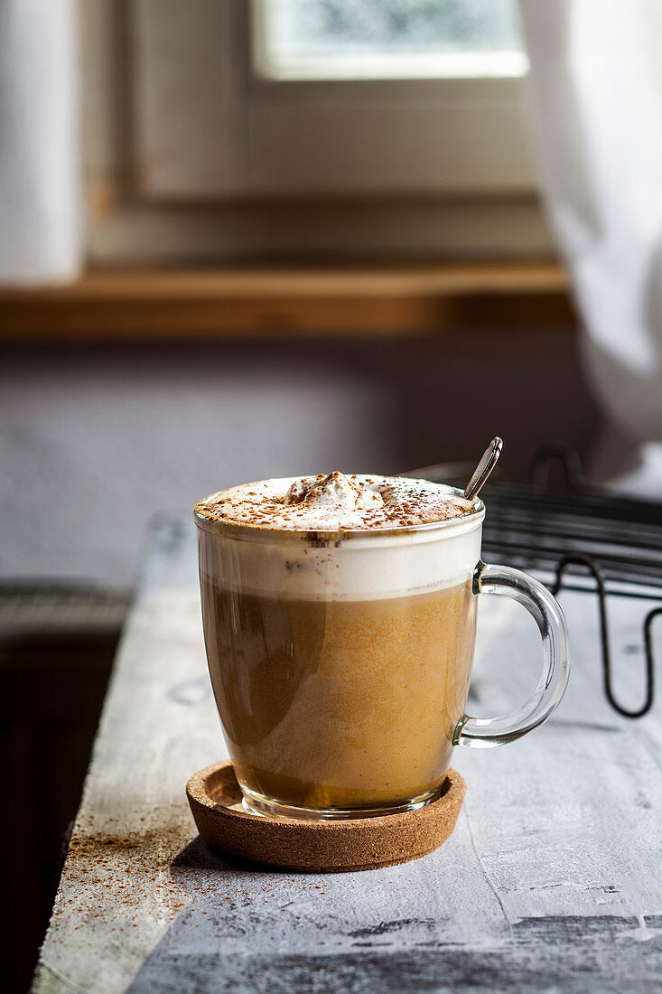 A pumpkin spice latte topped with cream and cinnamon