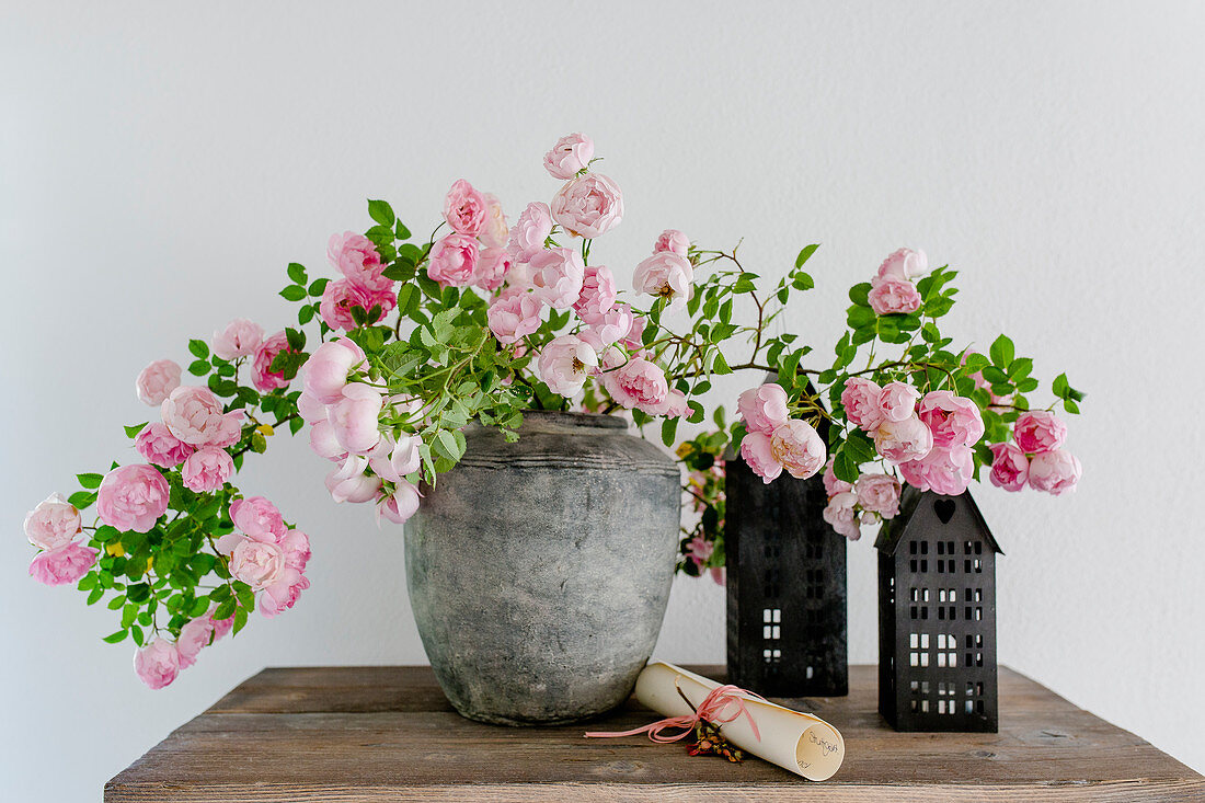 Arrangement of flowering rose branches in vase