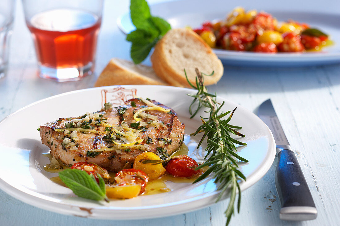 Grilled marinated pork loin steak with roasted tomatoes and baguette