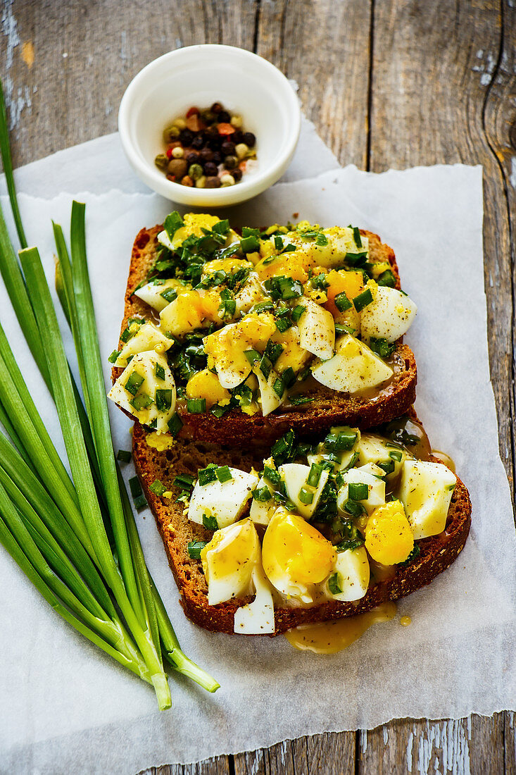 Getoastete Roggenbrotscheiben mit Ei und Frühlingszwiebeln